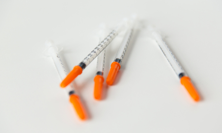 medicine, diabetes and health care concept - close up of insulin syringes on tableの写真素材