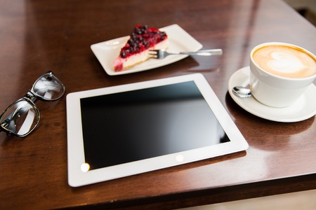 lifestyle, technology and object concept - close up of tablet pc computer, eyeglasses, coffee cup...
