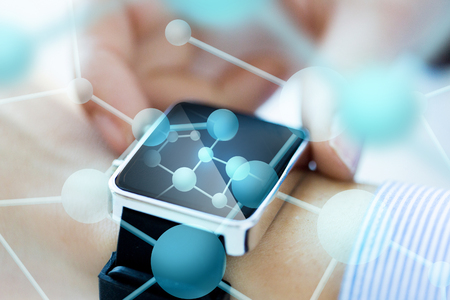 technology, science, chemistry, biology and people concept - close up of woman hands with molecules on smartwatchの写真素材