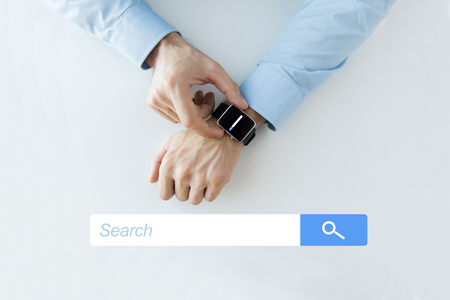 business, technology, and people concept - close up of male hands setting smart watch with web browser empty search bar on screenの写真素材