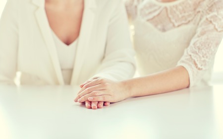people, homosexuality, same-sex marriage and love concept - close up of happy married lesbian couple handsの写真素材