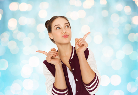people and teens concept - happy pretty teenage girl with eye makeup over blue holidays lights backgroundの写真素材