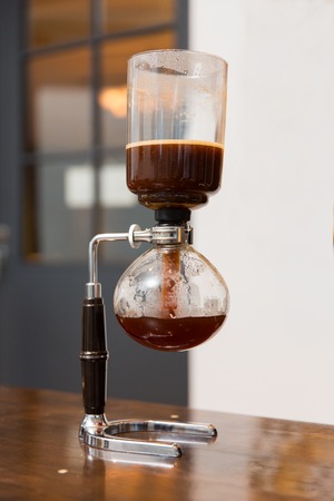 equipment, coffee shop and technology concept - close up of siphon vacuum coffee maker at shopの写真素材