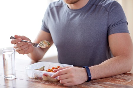 healthy eating, balanced diet, food and people concept - close up of male hands having meat and vegetables for dinner with fork and water glass healthy eating, balanced diet, food and people concept - close up of male hands having meat and vegetables for dinner with fork and water glass
