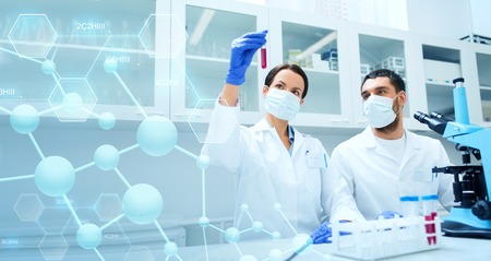 science, chemistry, technology, biology and people concept - young scientists with test tube and...