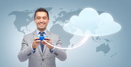 business, people, cloud computing and technology concept - happy businessman texting or reading...