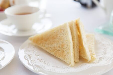 food, morning and eating concept - close up of toasted white bread on plate at breakfast on table