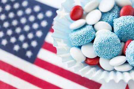 american independence day, celebration, patriotism and holidays concept - close up of glazed sweet candies with flag and paper stars decoration at 4th july theme partyの写真素材