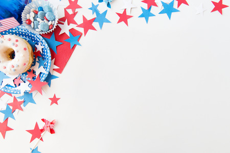 american independence day, celebration, patriotism and holidays concept - close up of glazed sweet donut with candies in disposable tableware and stars at 4th july party from topの写真素材