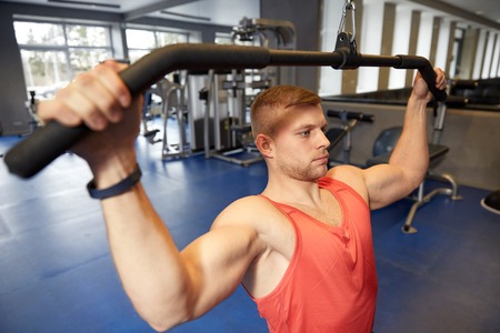 sport, fitness, bodybuilding, lifestyle and people concept - man exercising and flexing muscles on...
