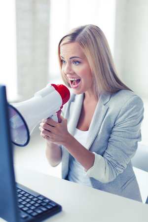picture of crazy businesswoman shouting in megaphoneの写真素材