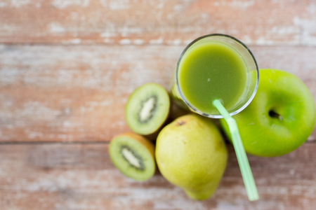 healthy eating, organic food and diet concept - close up of fresh green juice glass and fruits on tableの写真素材