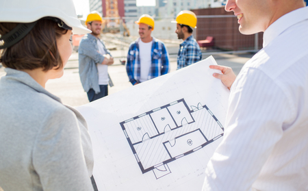 construction, architecture, business, teamwork and people concept - close up of architects with blueprint at building siteの素材 [FY31054443929]