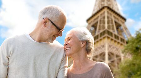 family, age, tourism, travel and people concept - happy senior couple over paris eiffel tower in...