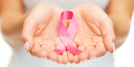 healthcare and medicine concept - womans hands holding pink breast cancer awareness ribbonの写真素材