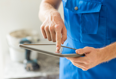 building, renovation, technology and people concept - close up of builder or workman hands with tablet pc computerの写真素材