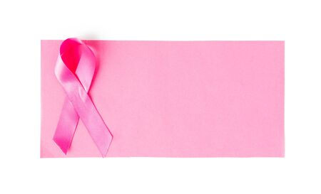 healthcare, charity, symbolics, oncology and medicine concept - close up of pink cancer awareness ribbon on blank paper sheetの写真素材