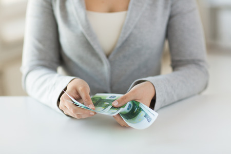 business, finance, saving, banking and people concept - close up of woman hands counting euro moneyの写真素材