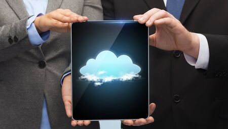business, technology and internet concept - businessman and businesswoman with cloud on tablet pc...