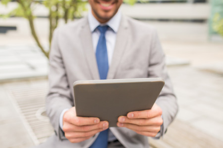 business, technology and people concept - close up of smiling man with tablet pc computer in city