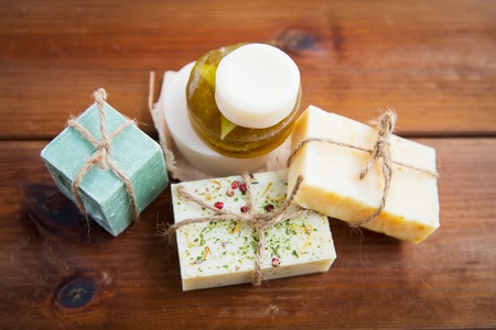 beauty, spa, body care, bath and natural cosmetics concept - close up of handmade soap bars on...