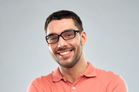 business, people and eyesight concept - portrait of happy smiling man in eyeglasses over gray...