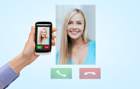 people, communication and technology concept - close up of female hand with incoming call on smartphoneの写真素材