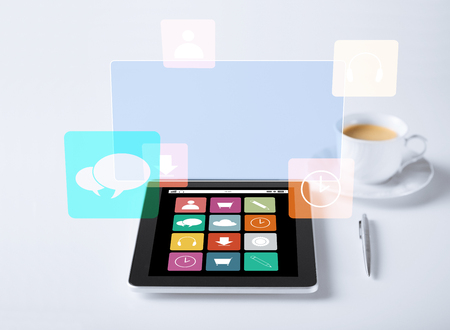 business, media and technology concept - tablet pc computer with application icons and cup of coffeeの写真素材