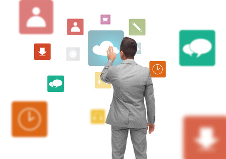 business, people, multimedia and cloud computing and office concept - businessman touching icon on virtual projection from backの写真素材