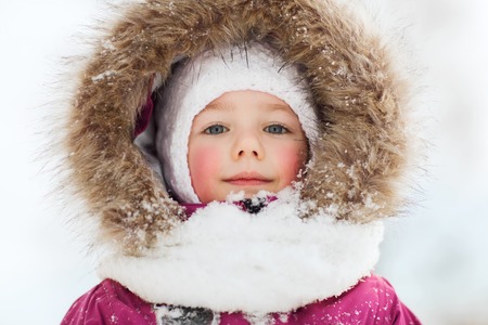 childhood, fashion, season and people concept - face of happy little kid or girl in winter clothesの写真素材