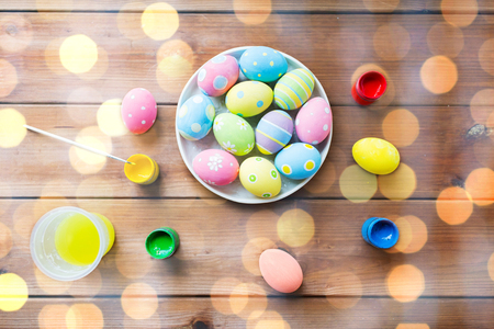 easter, holidays, tradition and object concept - close up of colored easter eggs on plateの写真素材