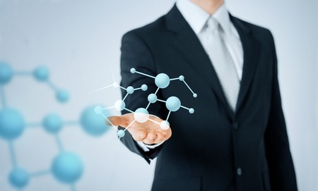 people, business, chemistry, science and biology concept - close up of man hand showing molecule formula projectionの写真素材