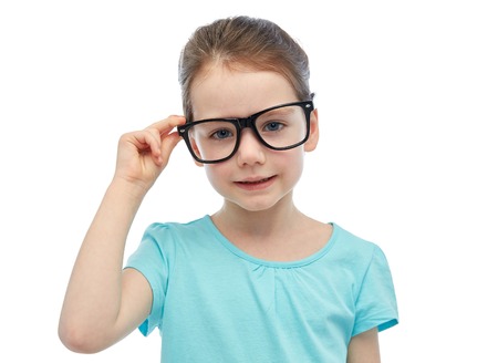 childhood, school, education, vision and people concept - happy little girl in eyeglassesの写真素材