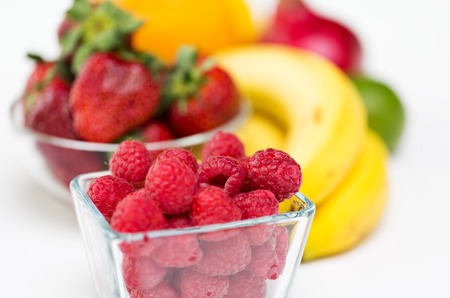 healthy eating, food and diet concept - close up of fresh raspberry and fruits on table