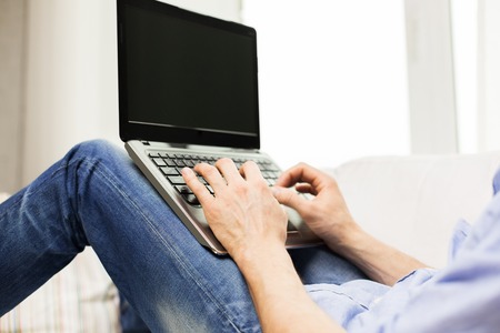 technology, people and lifestyle concept - close up of male hands typing on laptop computer keyboard at homeの写真素材