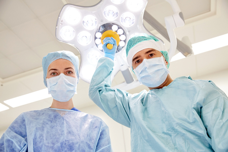 surgery, medicine and people concept - group of surgeons in operating room at hospital looking into cameraの写真素材