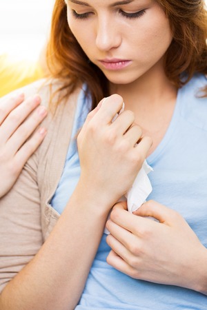 friendship, support, heartbreak and people concept - close up of crying teenage girl comforted by friendの写真素材