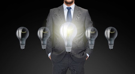 business, inspiration, startup, idea and people concept - close up of businessman in suit with ligh bulb iconsの写真素材