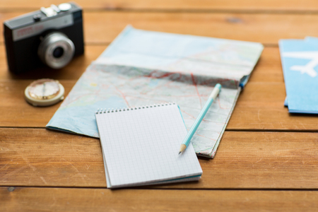vacation, tourism, travel and objects concept - close up of blank notepad with map and airplane ticketsの写真素材