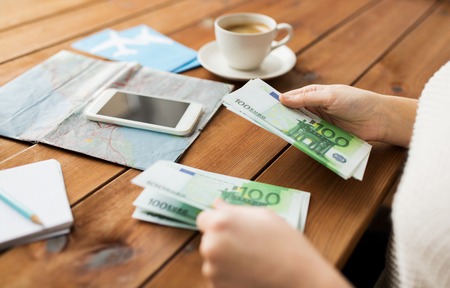 vacation, tourism, travel, finances and people concept - close up of traveler hands counting euro...
