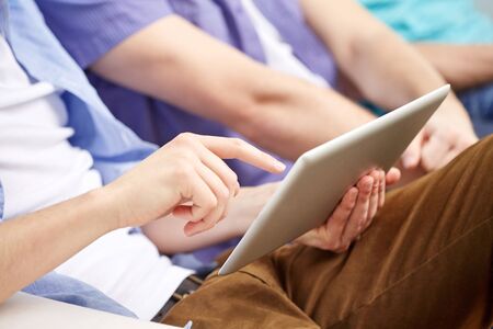 technology and people concept - close up of friends with tablet pc computers at home