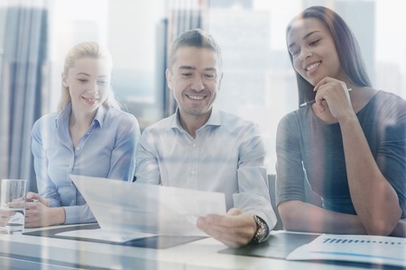 business, people and teamwork concept - group of smiling businesspeople meeting in officeの写真素材