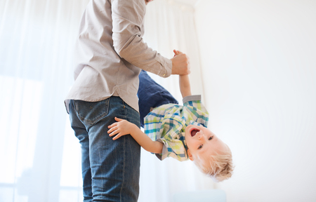 family, childhood, fatherhood, leisure and people concept - happy father and little son playing and having fun at homeの写真素材