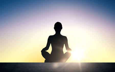 people, health, wellness and meditation concept - woman meditating in yoga lotus pose on stairs over sun light backgroundの写真素材