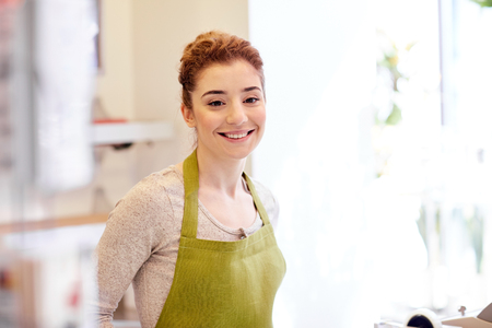 happy smiling florist woman or gardener at flower shopの写真素材