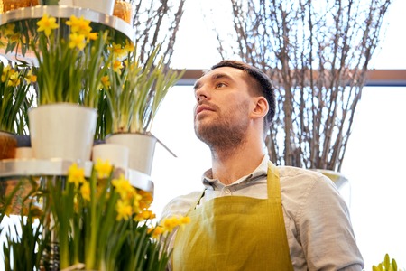 florist man with narcissus flowers at flower shopの写真素材