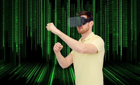 young man with virtual reality headset or 3d glasses playing game and fighting over binary code...