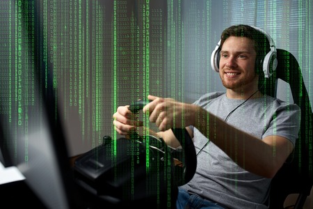 technology, gaming, entertainment and people concept - happy smiling young man in headphones with pc...