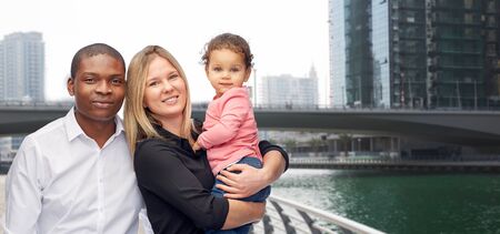 family, travel, tourism and international concept - happy multiracial mother, father and little...