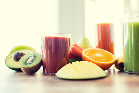 healthy eating, food and diet concept- close up of fresh juice glass and fruits on tableの写真素材